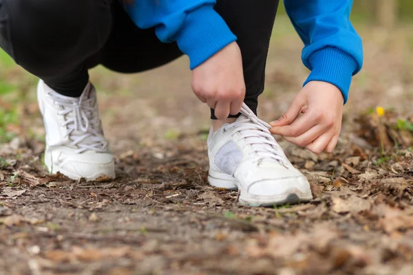 Frau zieht Schnürsenkel enger — Stockfoto