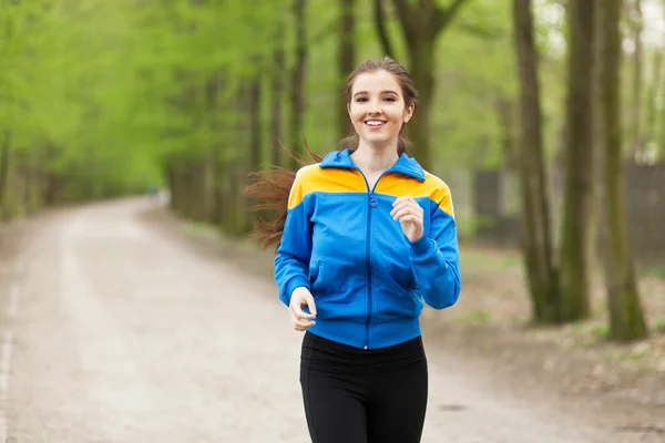 Joven hermosa mujer corriendo en un sendero — Foto de Stock