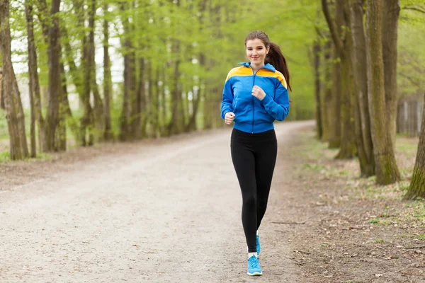 Jeune belle femme courant sur un sentier — Photo