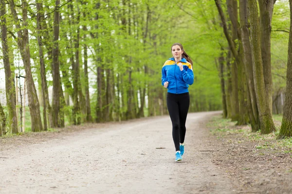 Jeune belle femme courant sur un sentier — Photo