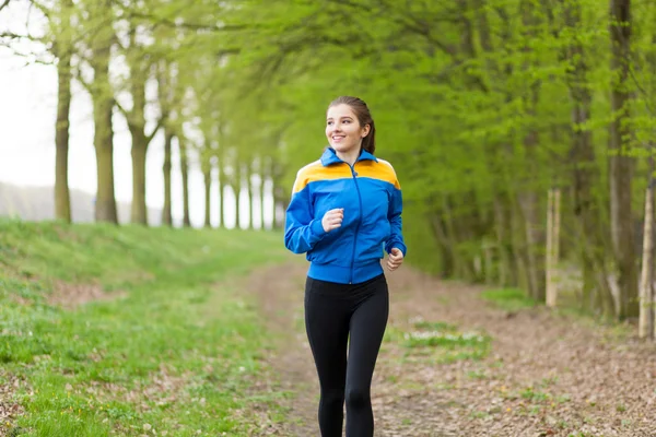 Young beautiful woman running on a trail — Stock Photo, Image