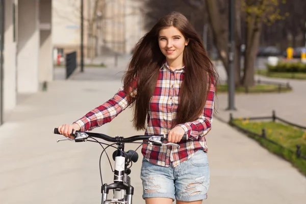 Joven hermosa mujer en una bicicleta — Foto de Stock