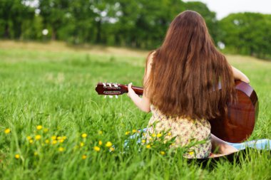 Gitar çalan genç bir kadın
