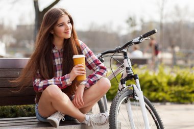 Genç kadın bir bisiklet gezisi kahve içme