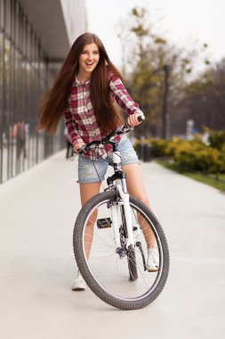 Bir bisiklet üzerinde genç güzel kadın