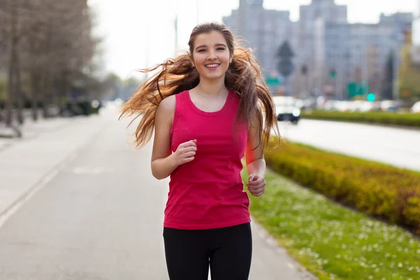 Young beautiful woman running in the city — Stock Photo, Image