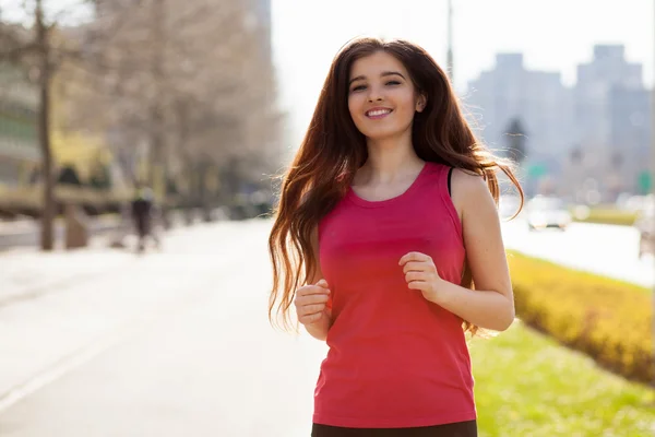 Young beautiful woman running in the city — Stock Photo, Image