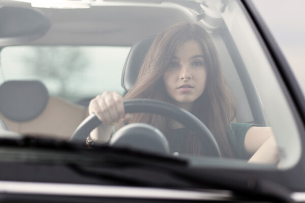 Young beuatiful woman driving a car