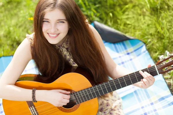 Jonge vrouw spelen een gitaar — Stockfoto