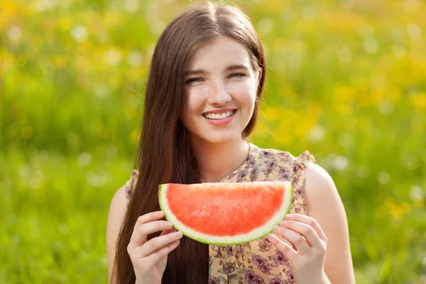 Junge schöne Frau isst eine Wassermelone — Stockfoto