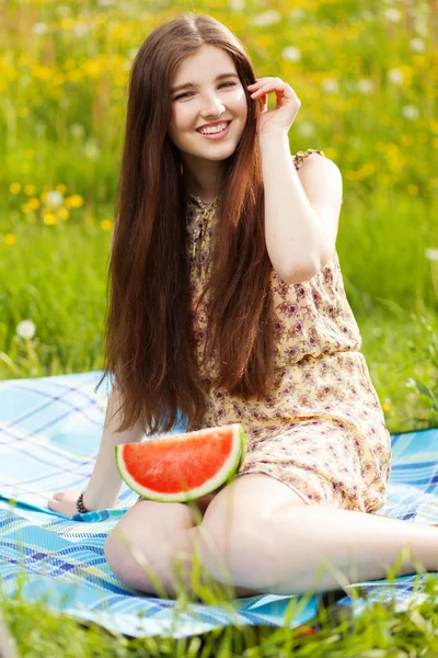 Junge schöne Frau isst eine Wassermelone — Stockfoto