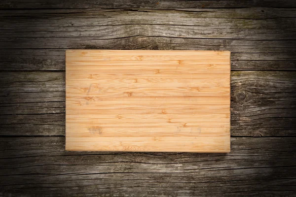 Доска резки на деревянном фоне — стоковое фото