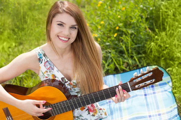 Jeune femme jouant une guitare — Photo