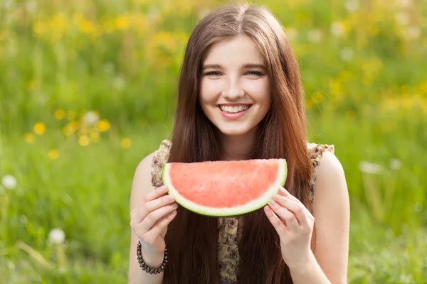 Junge schöne Frau isst eine Wassermelone — Stockfoto