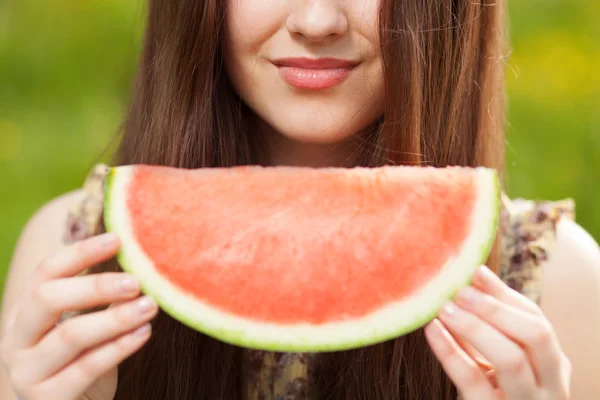 Junge schöne Frau isst eine Wassermelone — Stockfoto