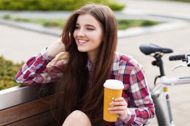 Genç kadın bir bisiklet gezisi kahve içme