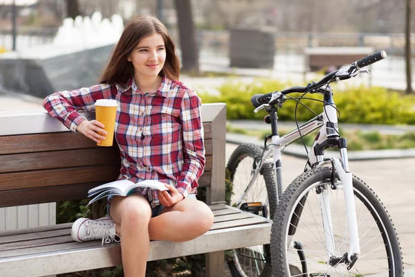 Giovane donna che beve caffè in un viaggio in bicicletta — Foto Stock
