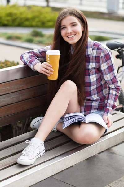 Mladá žena pití kávy na cyklovýletu — Stock fotografie