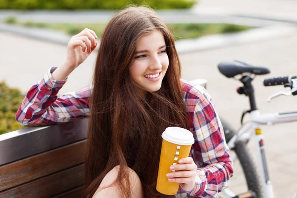 Jonge vrouw drinken koffie op een fietstocht — Stockfoto