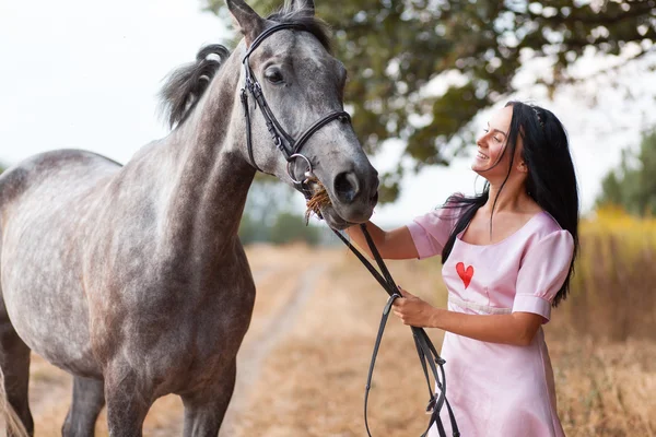 Jonge vrouw met een paard — Stockfoto