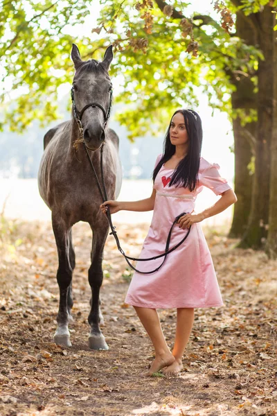 Jonge vrouw met een paard — Stockfoto