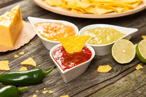 Tallrik med nachos med olika dips — Stockfoto