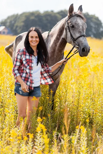 Jonge vrouw met een paard — Stockfoto