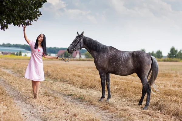 Jonge vrouw met een paard — Stockfoto
