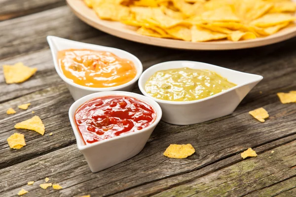 Tallrik med nachos med olika dips — Stockfoto