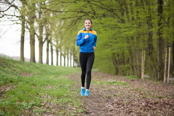 Young beautiful woman running on a trail — Stock Photo, Image