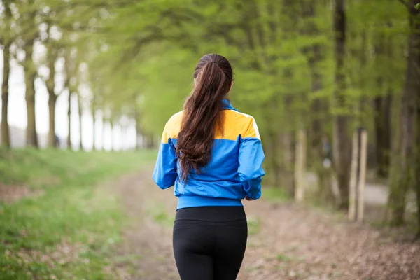 Joven hermosa mujer corriendo en un sendero — Foto de Stock