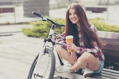Genç kadın bir bisiklet gezisi kahve içme