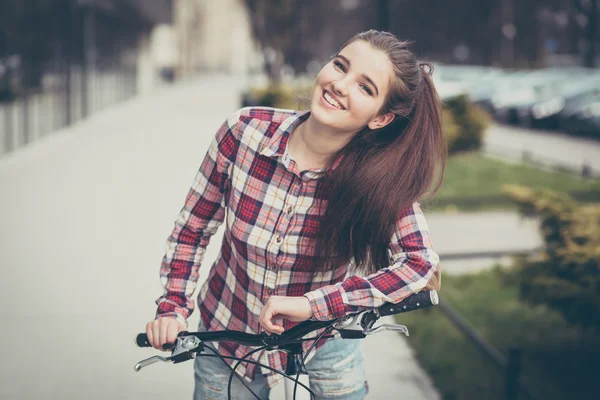 Mulher bonita nova em uma bicicleta — Fotografia de Stock