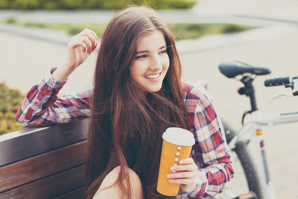 Jovem mulher bebendo café em uma viagem de bicicleta — Fotografia de Stock