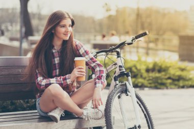 Genç kadın bir bisiklet gezisi kahve içme