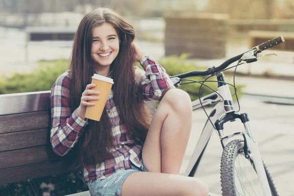 Junge Frau trinkt Kaffee auf einer Fahrradtour — Stockfoto