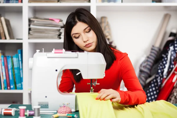 Jeune femme à une machine à coudre — Photo