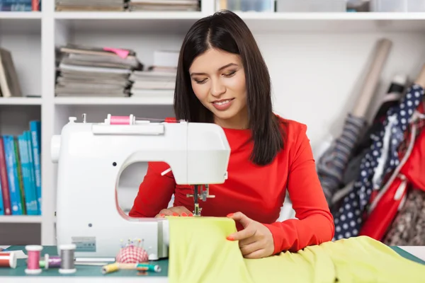 Mujer joven en una máquina de coser —  Fotos de Stock