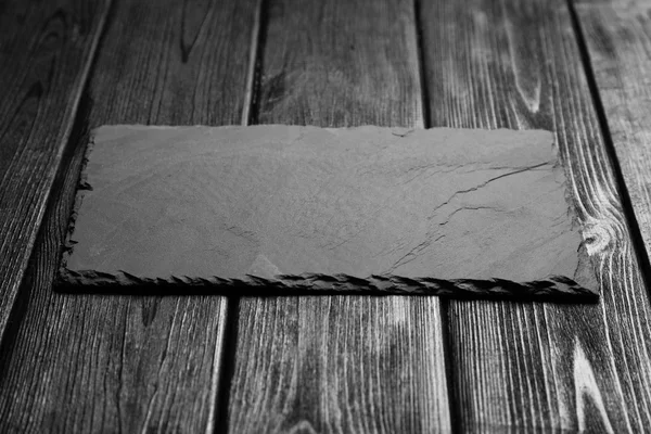 Black slateboard on dark wood — Stock Photo, Image