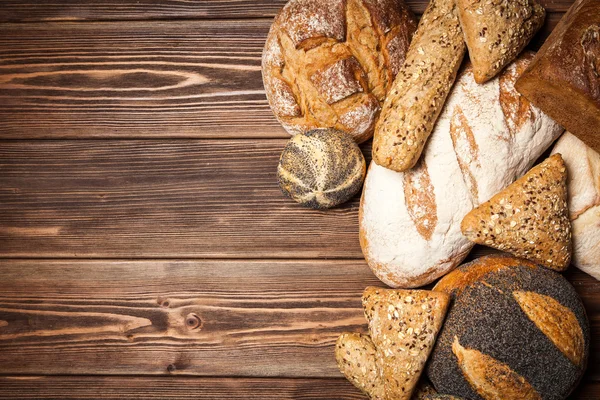 Bread assortment on wooden surface — Stock Photo, Image