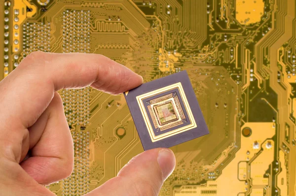Microprocessor in hand over PCB — Stock Photo, Image