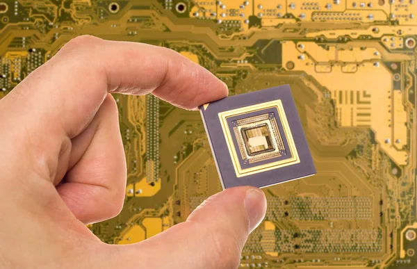 Microprocessor in hand over PCB — Stock Photo, Image