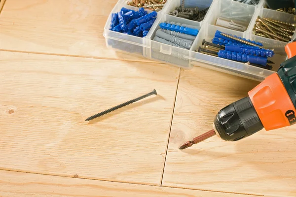 Cordless drill, schroeven en toolbox op een houten achtergrond — Stockfoto