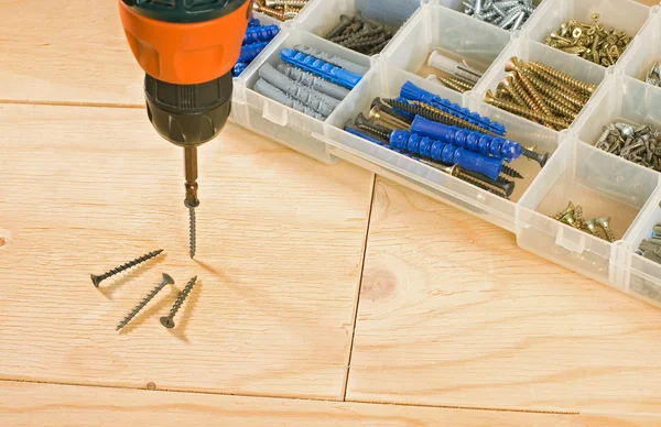 Cordless drill, schroeven en toolbox op een houten achtergrond — Stockfoto