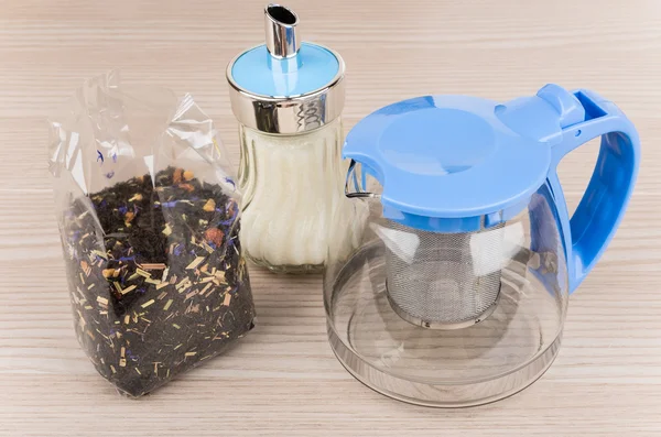 The package of tea, glass teapot and sugar bowl