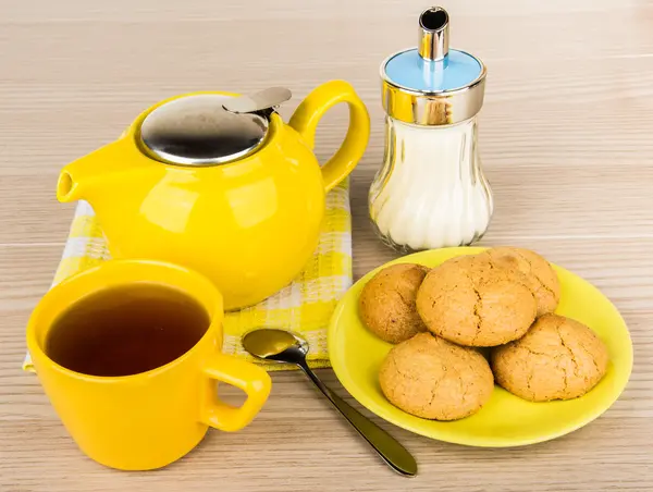 Yellow tea cup with tea and cookies