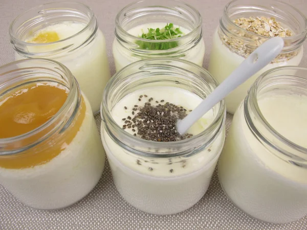 Yogurt in jars from yogurt maker with topping — Stock Photo, Image