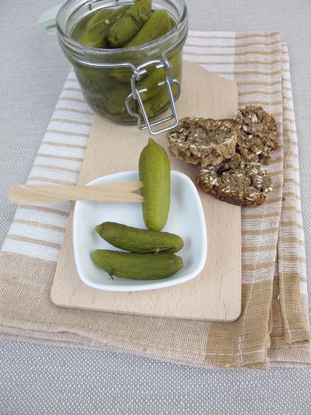 Pickled cucumber in jar and bread — Stock Photo, Image