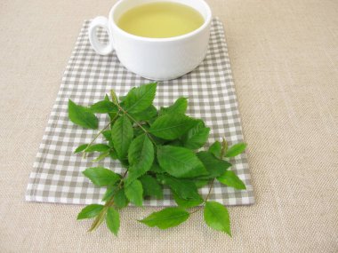 Bir fincan gül yapraklı bitki çayı.