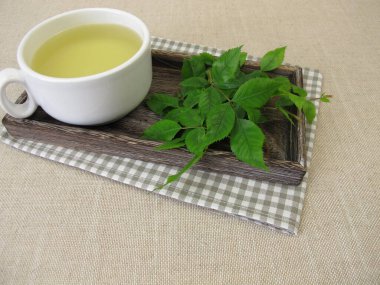 Bir fincan gül yapraklı bitki çayı.